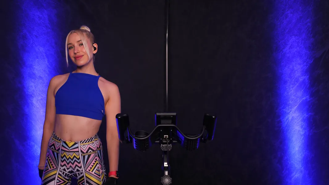 Sophie steht neben einem Indoor-Cycling-Bike