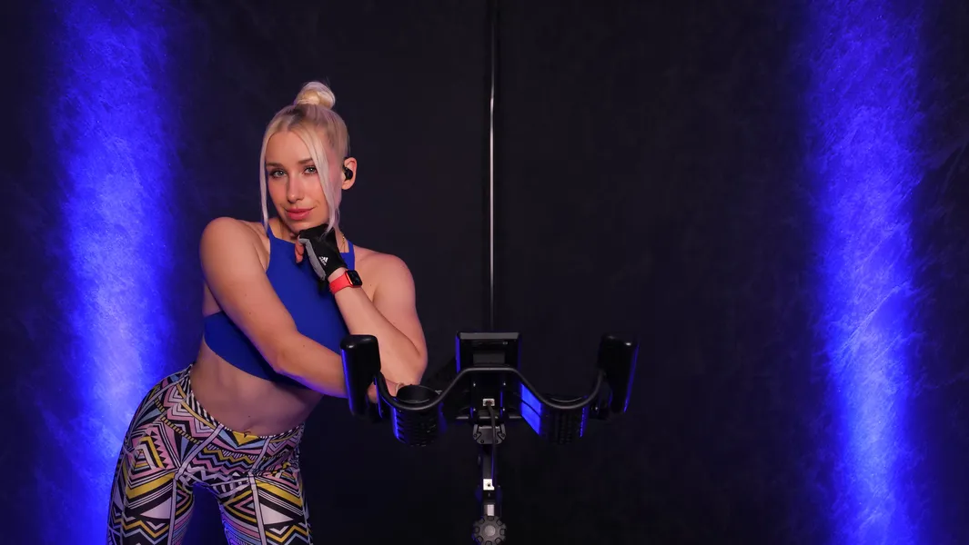Sophie steht neben einem Indoor-Cycling-Bike