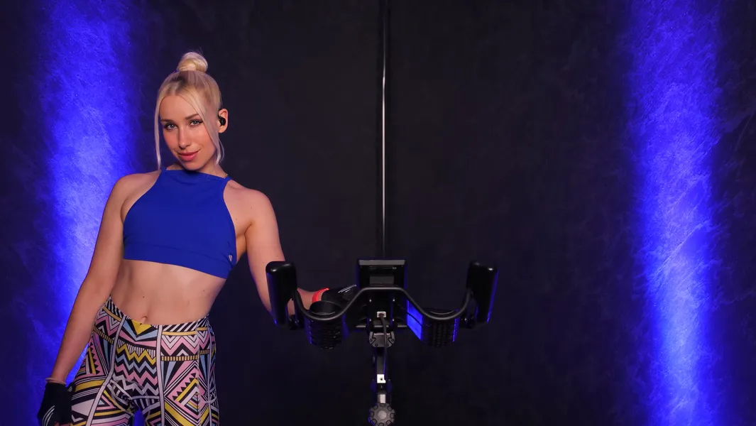 Sophie steht neben einem Indoor-Cycling-Bike