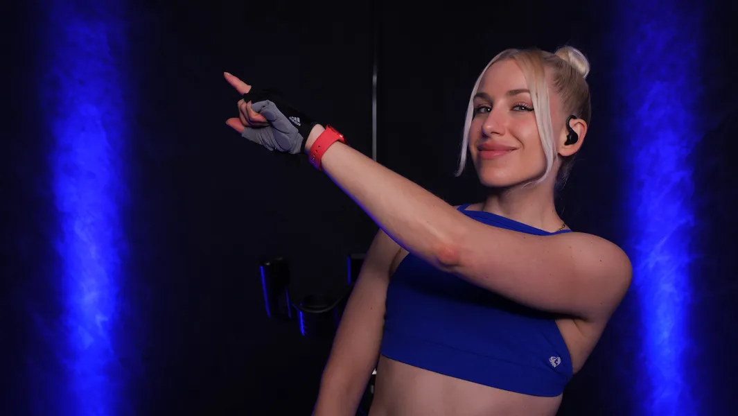 Sophie im blauen Sporttop mit ausgestrecktem Arm